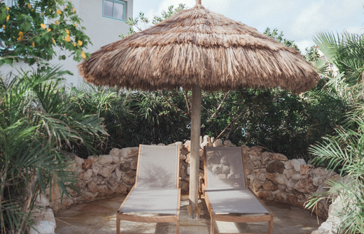 two lounge chairs with palapa in secluded area 